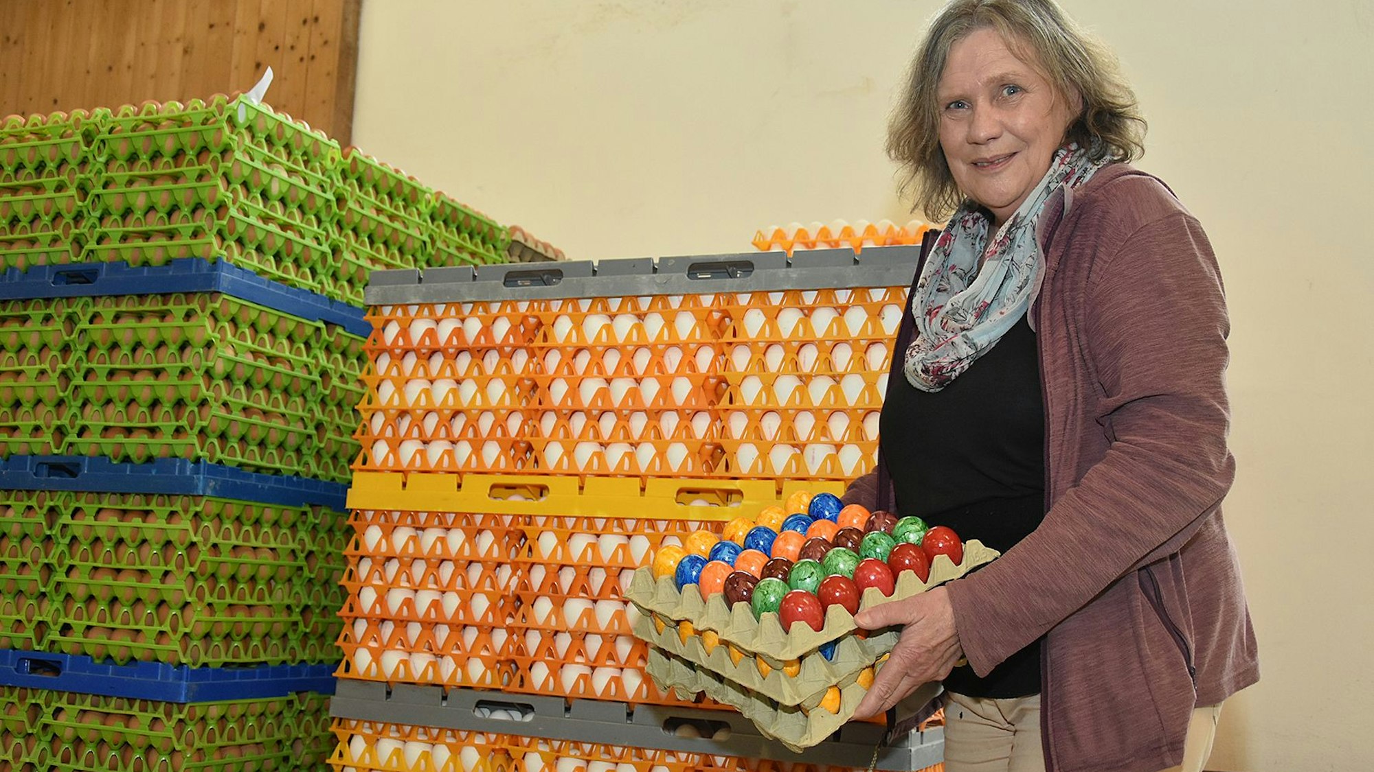 Mechthild Klose hält eine Palette gefärbter Eier in den Händen.