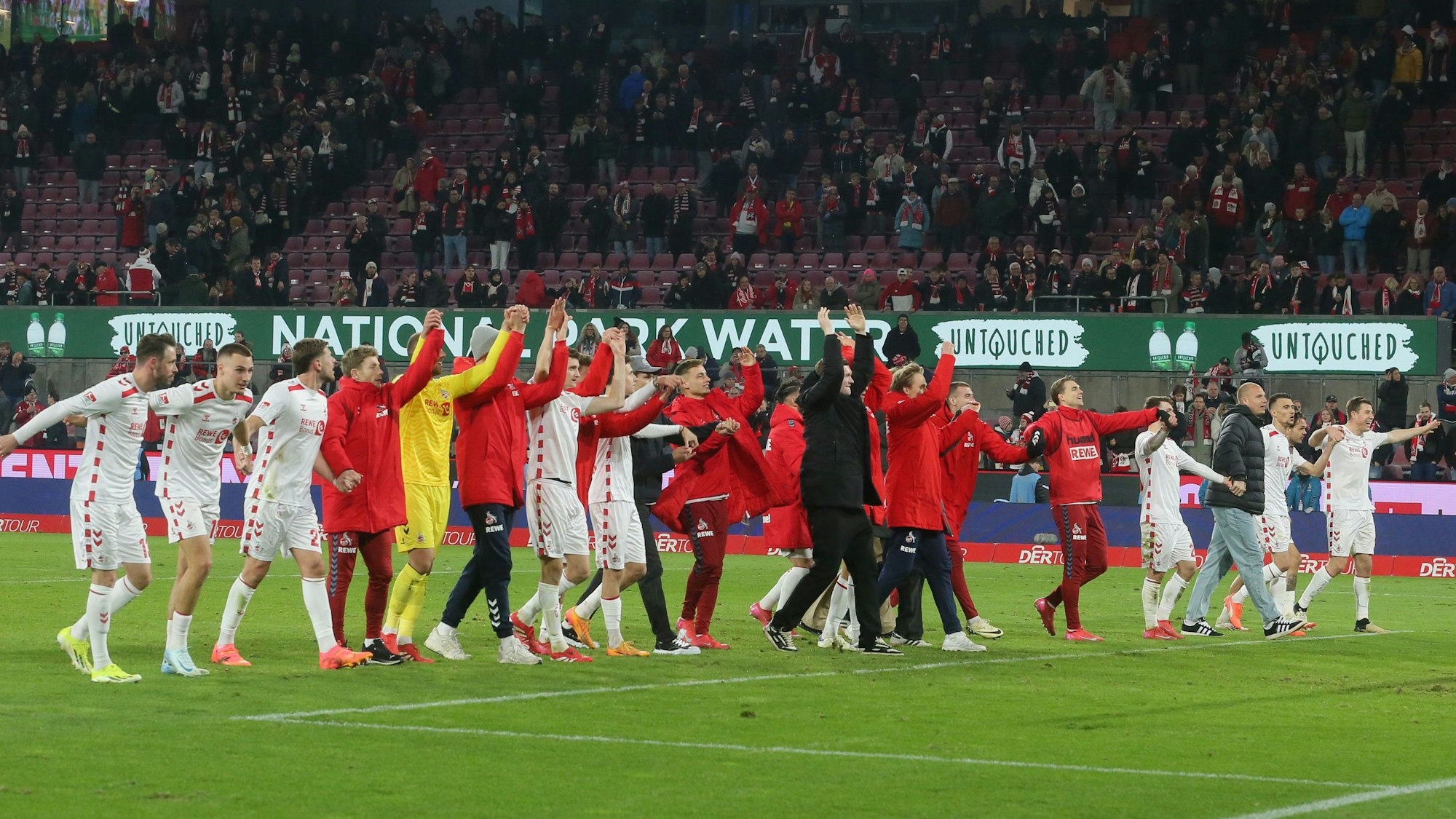 Die Mannschaft des 1. FC Köln jubelt nach dem Spiel vor der Südtribüne.