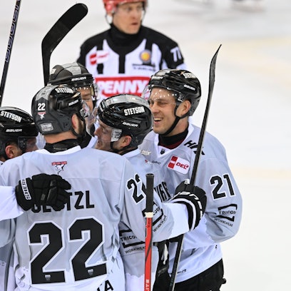 Die Kölner Maximilian Glötzl, Juhani Tyrväinen (21) und Parker Tuomie (l) jubeln über ein Tor.