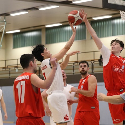 Zwei Basketballspieler steigen zum Ball hoch und versuchen ihn zu bekommen.