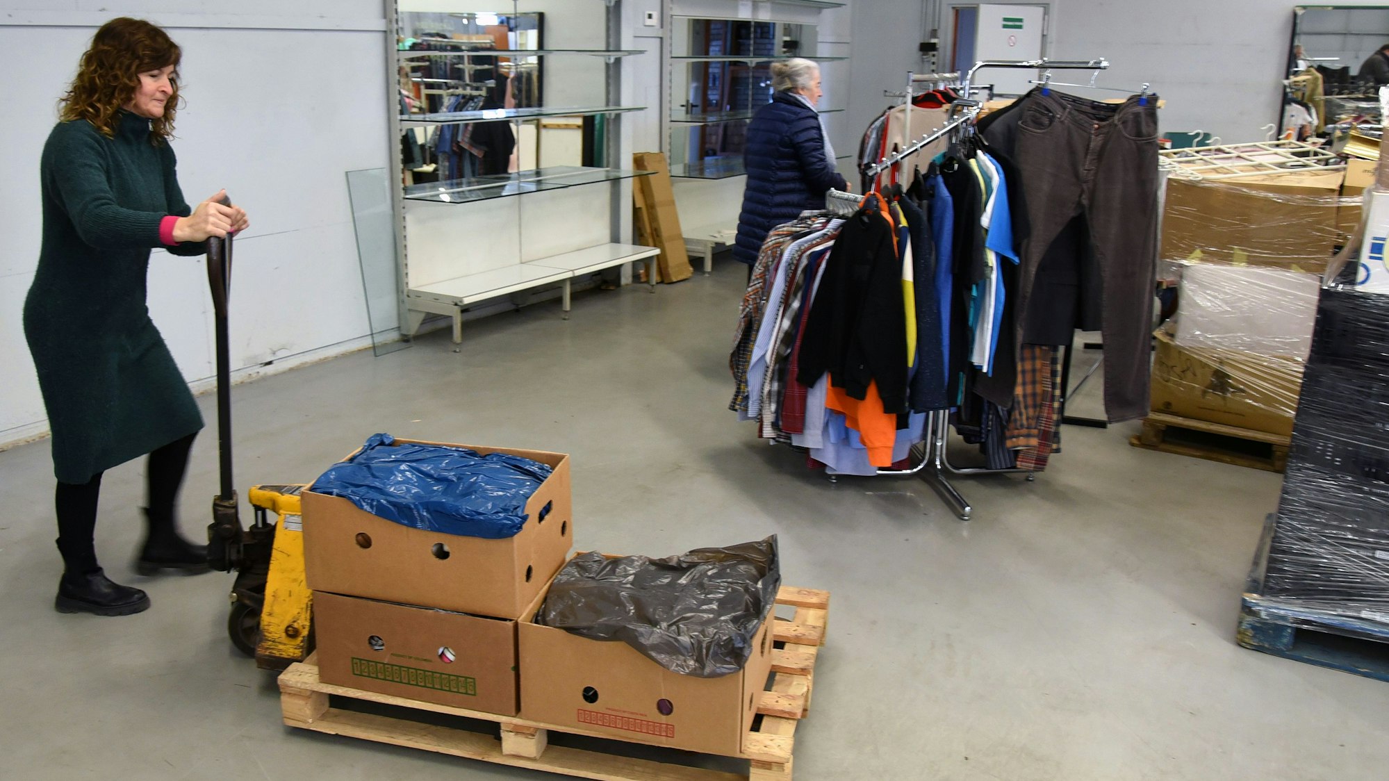 Mitarbeiterin Lilli Lerche kurvt mit einer Ameise durch die neuen Verkaufsräume in Waldbröl-Hermesdorf. Später packt sie Schuhe in die frisch installierten Regale.