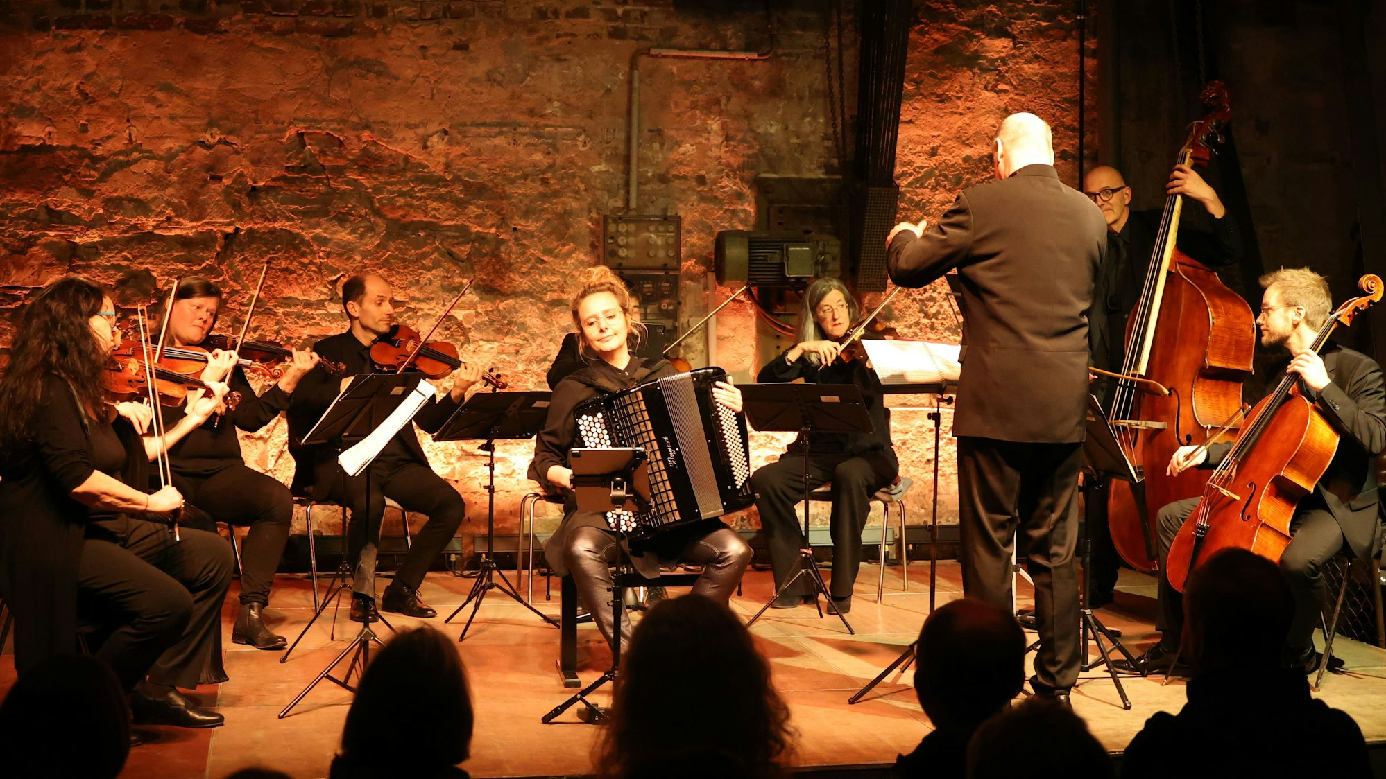 Ein Orchester musiziert in einer alten Fabrik.