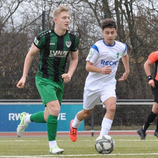 Das Foto zeigt zwei Fußballer im Zweikampf: der Königsdorfer in Weiß läuft seinem Gegenspieler im grün-schwarz gestreiften Dress hinterher.