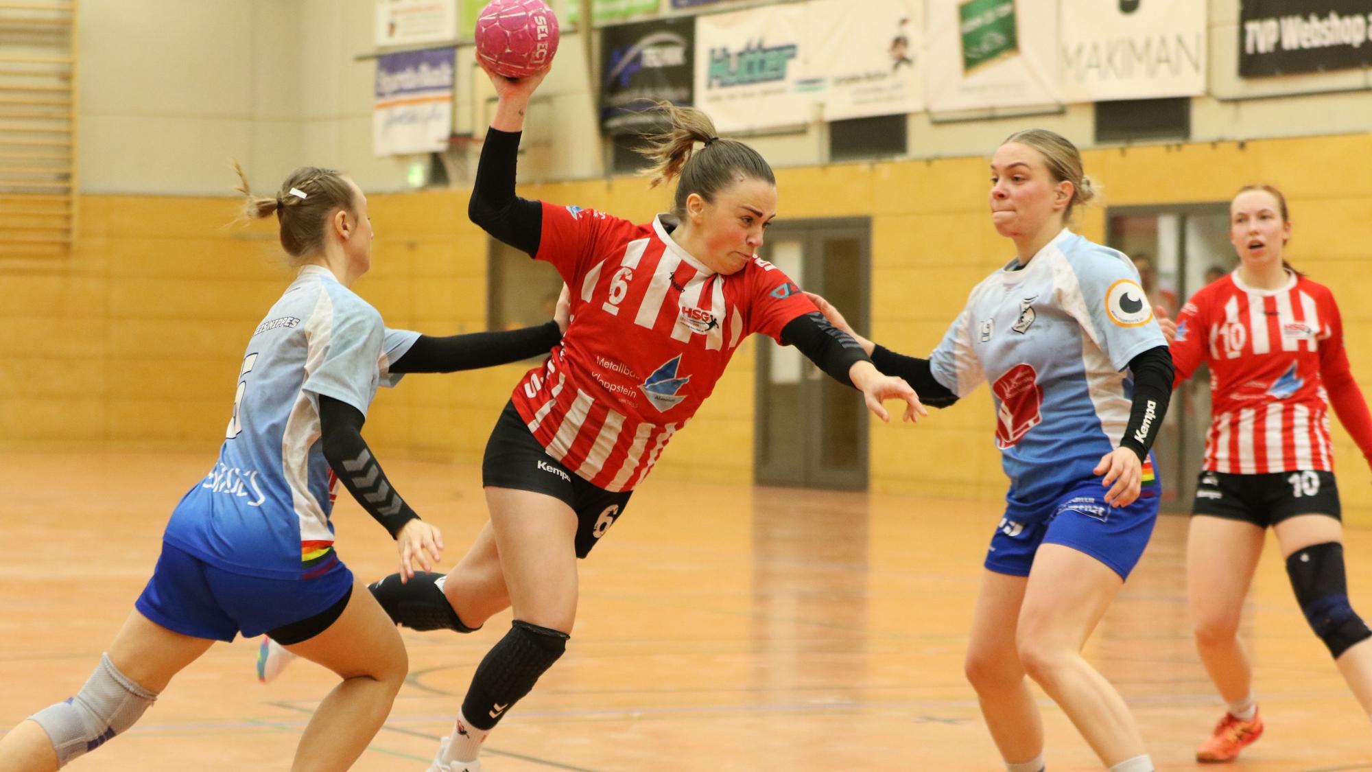 Svenja Bank stürmt mit dem Ball in der Hand Richtung Tor. Zwei Gegenspielerinnen sind an ihr dran, können sie aber nicht stoppen.