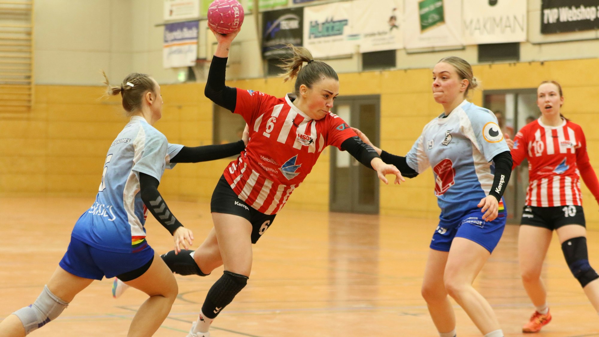 Svenja Bank stürmt mit dem Ball in der Hand Richtung Tor. Zwei Gegenspielerinnen sind an ihr dran, können sie aber nicht stoppen.