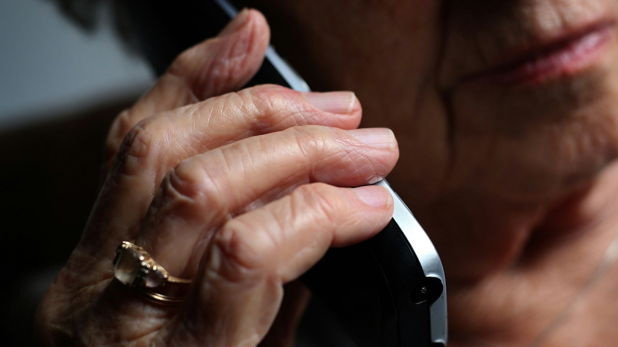 Eine ältere Frau telefoniert mit einem schnurlosen Festnetztelefon (Symbolfoto).