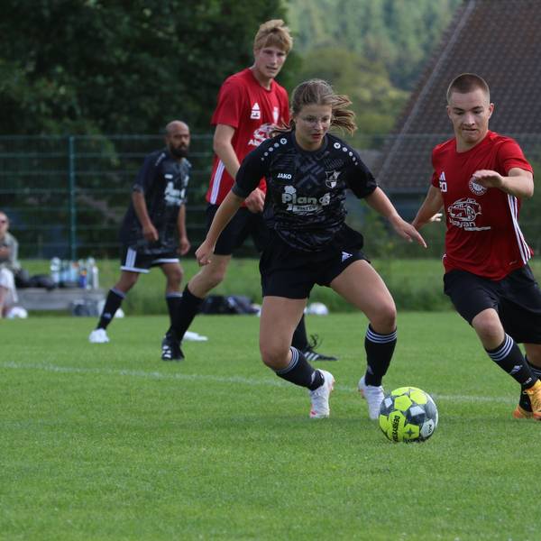 Das Bild zeigt die Spielerin Ophelia Rosenbaum im Zweikampf bei einem Fußballspiel.