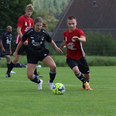 Das Bild zeigt die Spielerin Ophelia Rosenbaum im Zweikampf bei einem Fußballspiel.