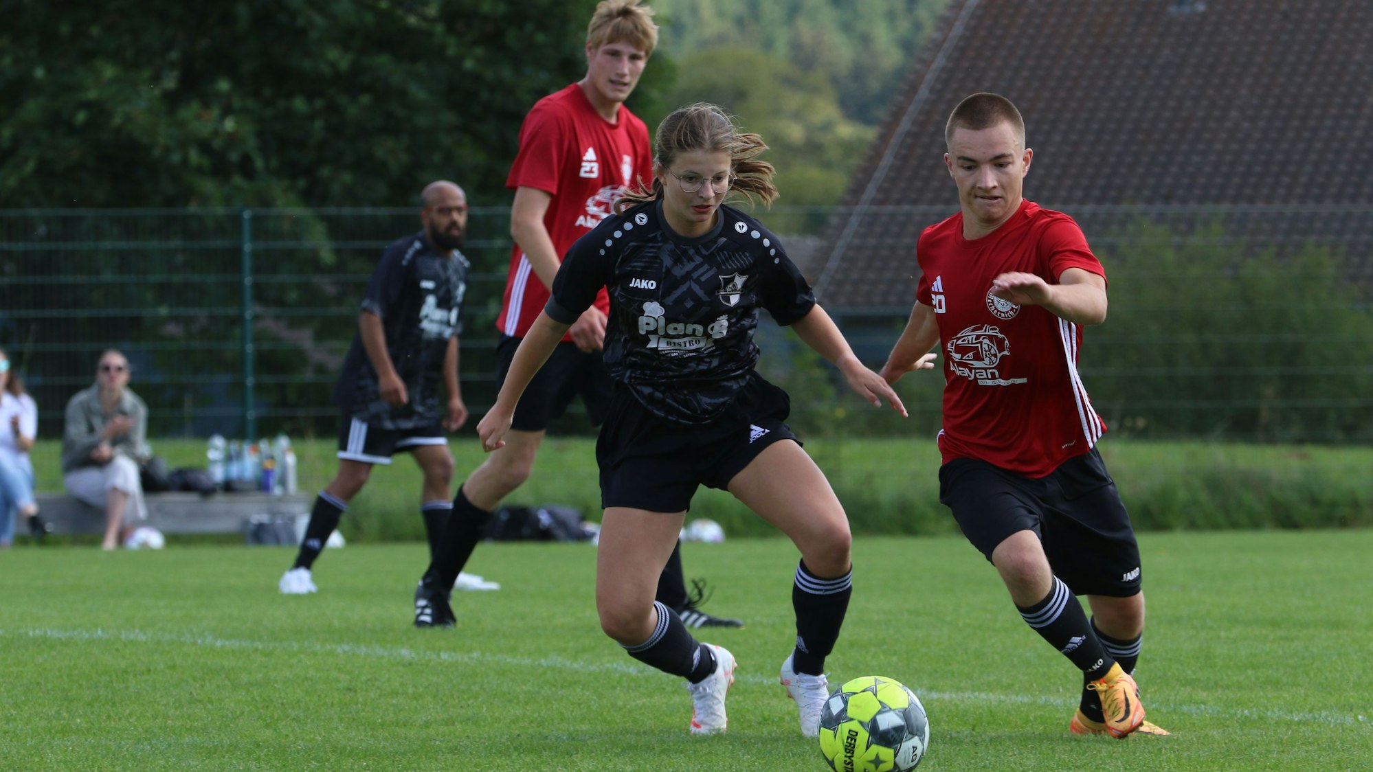 Das Bild zeigt die Spielerin Ophelia Rosenbaum im Zweikampf bei einem Fußballspiel.