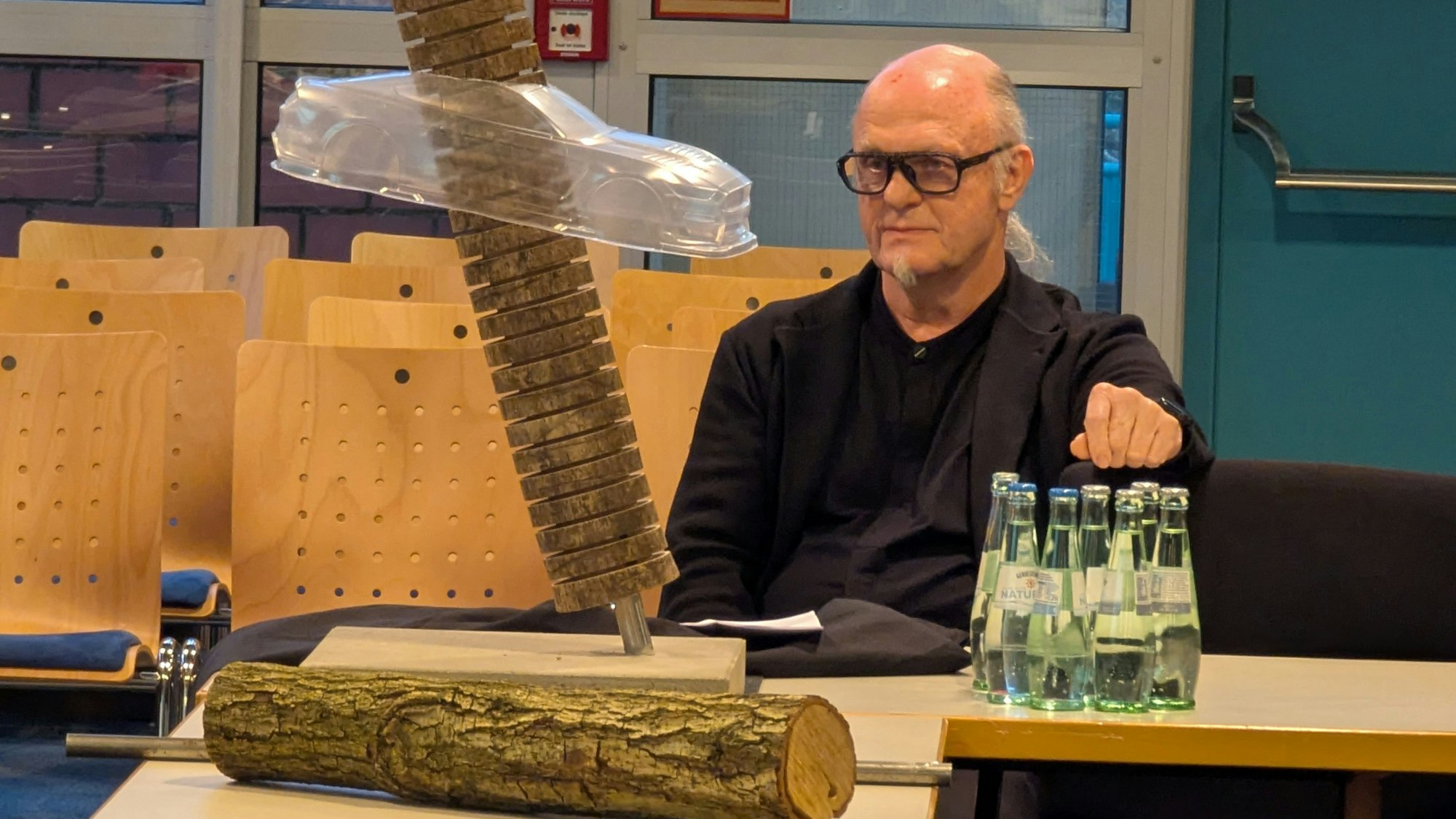 Das Foto zeigt den Künstler, vor sich auf dem Tisch ein Modell des Kunstwerks.