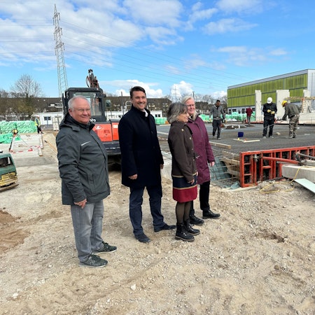 An der Bodenplatte des zweiten Bauabschnitts der Gertrud-Koch-Gesamtschule stehen: Michael Mäder, Projektleiter der Stadt, Bürgermeister Alexander Biber, Schulleiterin Kirsten Heinrichs mit ihrer Stellvertreterin Veronika Diers (v.l.).