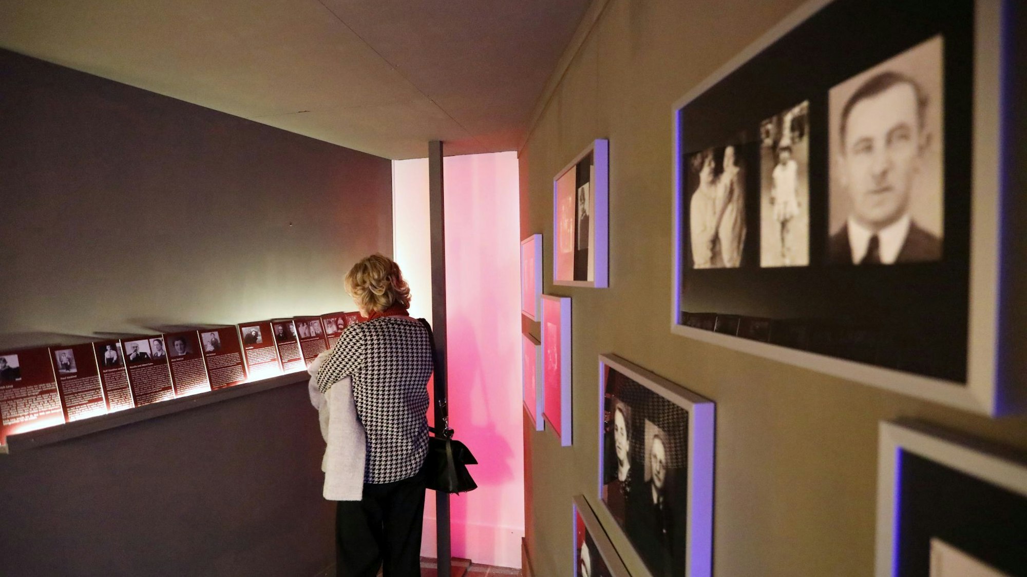 In einem Ausstellungsraum hängen Bilderrahmen mit Porträtfotos von NS-Opfern an der Wand.