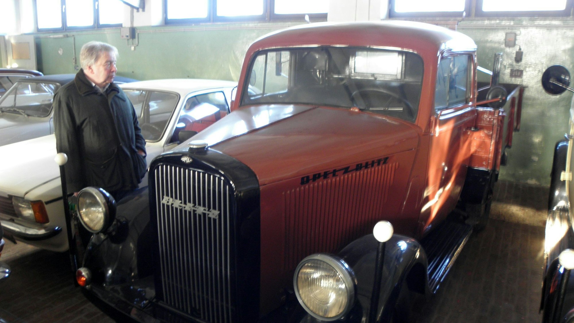 Der Opel-Blitz-Lastwagen ist zwischen anderen Oldtimern eingeparkt worden. Martin Degener betrachtet den Wagen genauer.