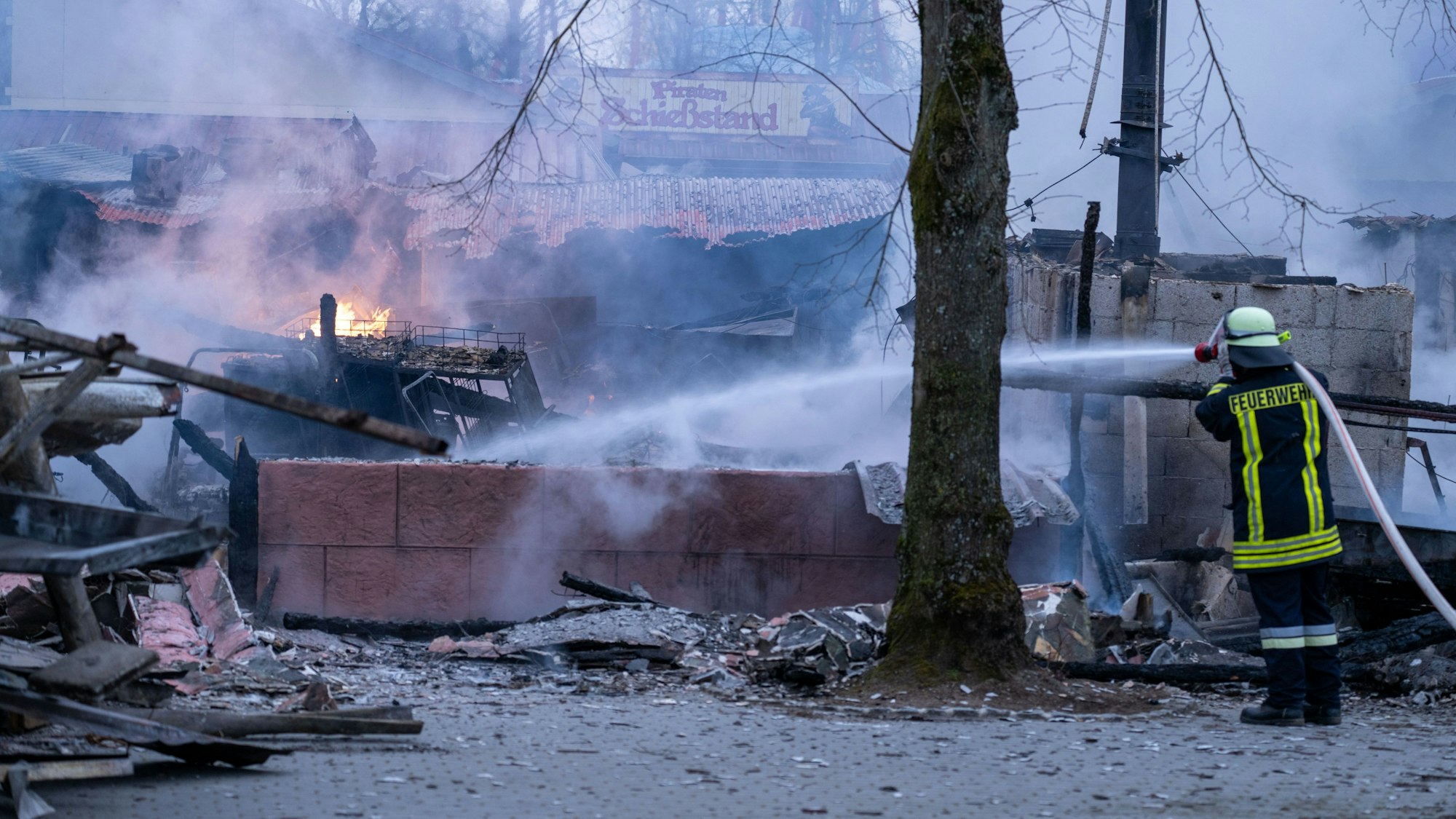 Ein Feuerwehrmann versucht die letzten Flammen im „Freizeit-Land Geiselwind“ zu löschen.
