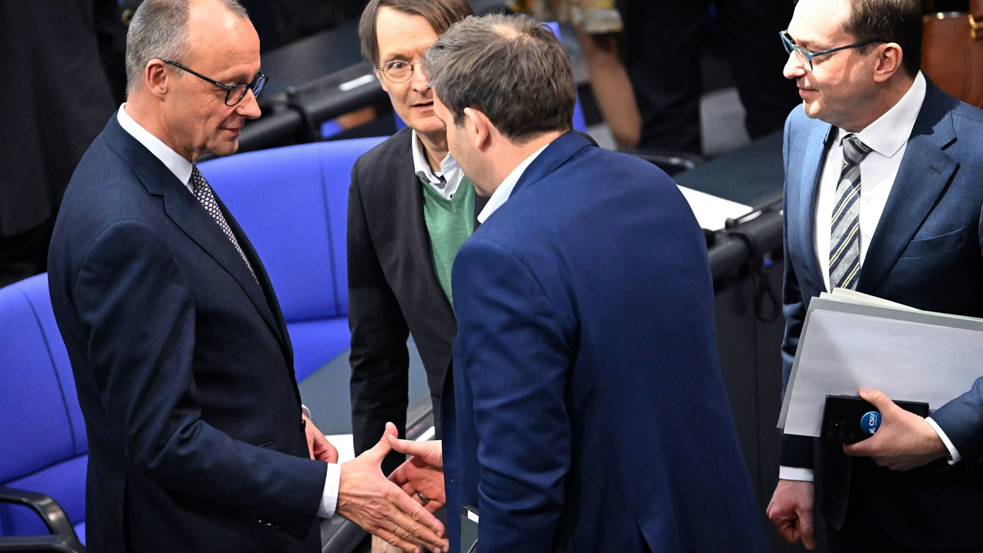 18.03.2025, Berlin: SPD-Fraktionsvorsitzender Lars Klingbeil (M) gibt Friedrich Merz (l), CDU/CSU Fraktionsvorsitzender und Bundesvorsitzender, die Hand nach der 214. Plenarsitzung der 20. Legislaturperiode im Deutschen Bundestag. In der Mitte Gesundheitsminister Karl Lauterbach (SPD) und rechts CSU-Landesgruppenchef Alexander Dobrindt. Hauptthema dieser zweiten Sondersitzung des alten Bundestages nach der vorgezogenen Bundestagswahl ist die Reform der Schuldenbremse als Voraussetzung für das geplante milliardenschwere Finanzpaket der zukünftigen Bundesregierung für Verteidigung, Infrastruktur, und Klimaschutzmaßnahmen. Foto: Bernd von Jutrczenka/dpa +++ dpa-Bildfunk +++