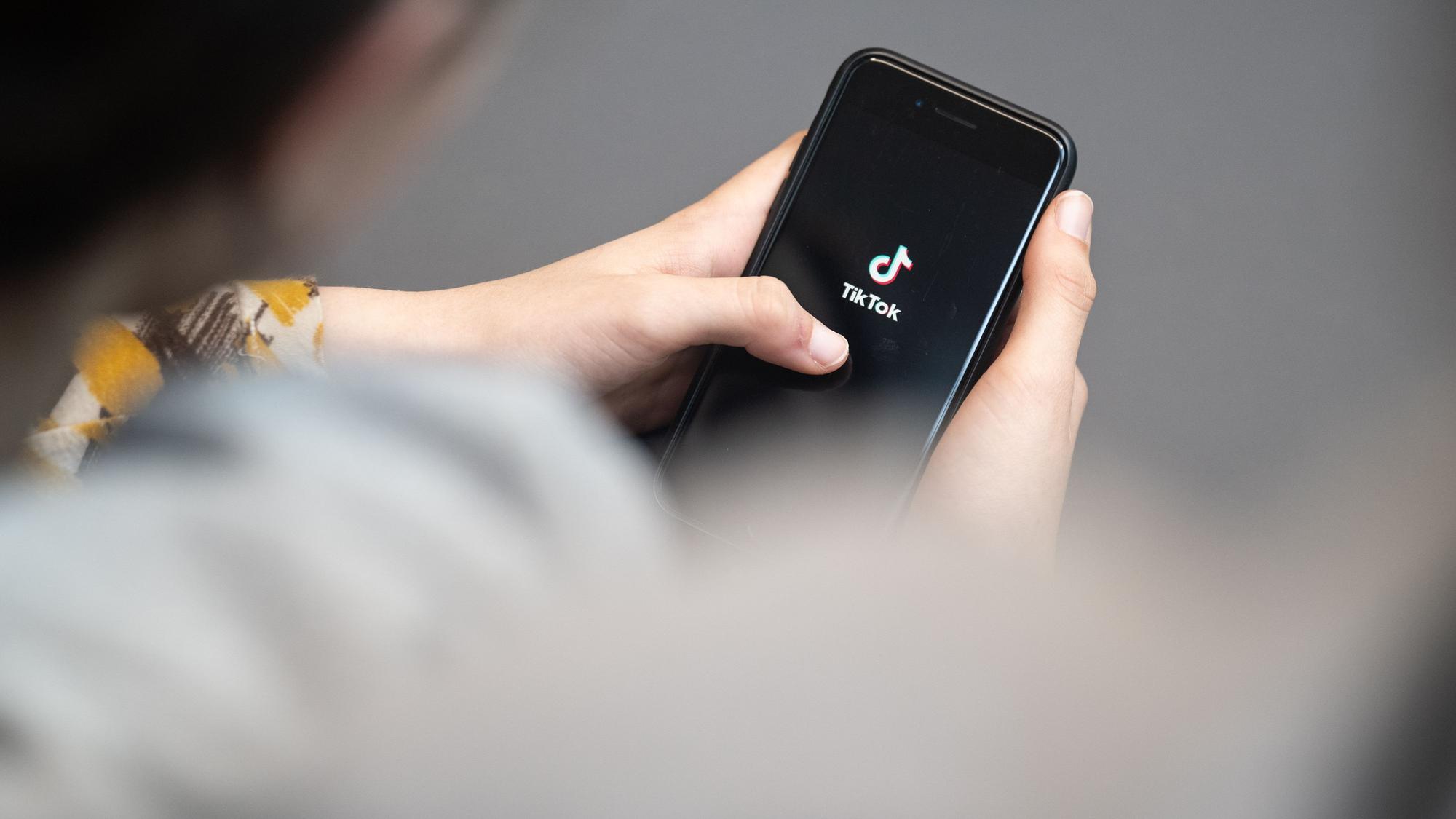 ARCHIV - 25.04.2024, Berlin: Eine Jugendliche schaut auf ein Smartphone mit angezeigtem Tiktok-Logo. (zu dpa: «Umfrage: Junge Menschen denken anders über China») Foto: Hannes P Albert/dpa +++ dpa-Bildfunk +++