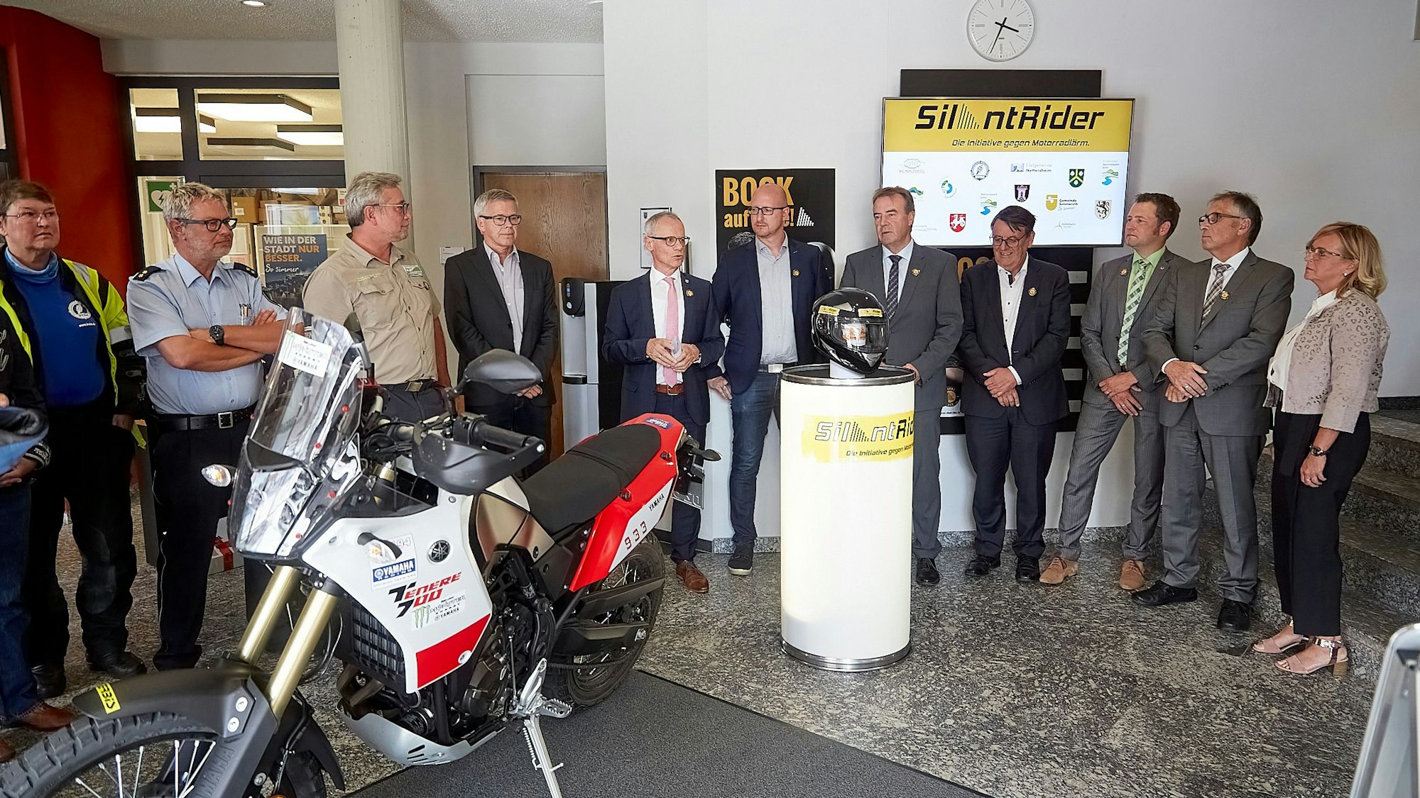 Das Foto zeigt die Vertreter der Kommunen, die sich hinter einem Motorrad aufgestellt haben.