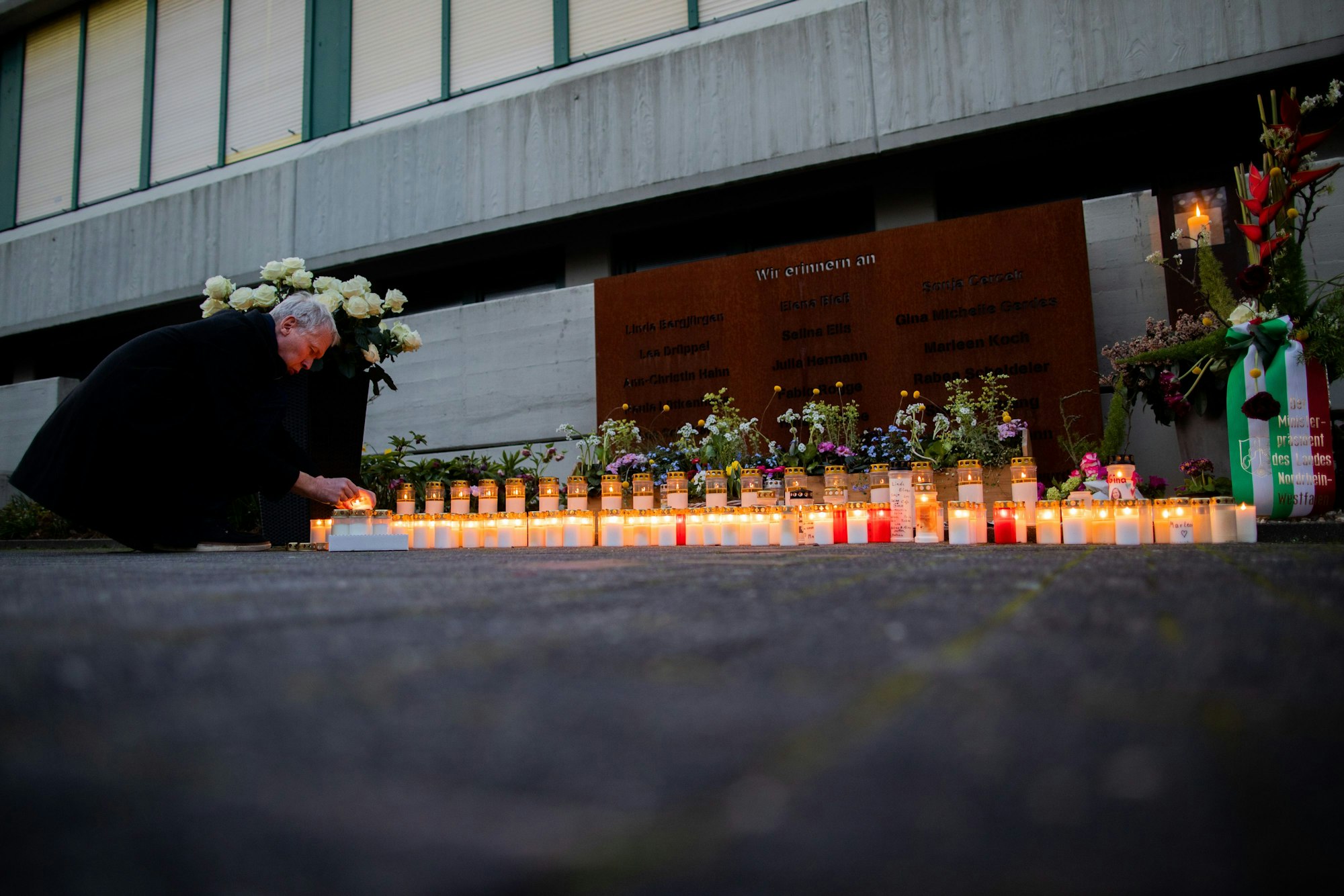 Ulrich Wessel, ehemaliger Schulleiter des Joseph-König-Gymnasiums in Haltern am See, entzündet eine Kerze vor der Gedenkstätte.