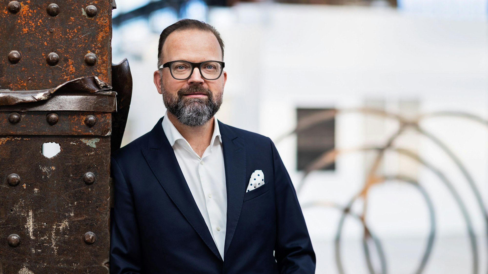 Walter Gehlen lehnt an einem Stahlpfeiler in der Messehalle.