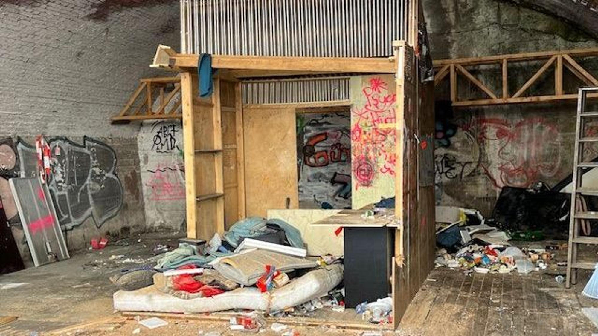 Noch nicht geräumter Bogen an der Hüttenstraße: Zu sehen sind Holzbauten, eine alte Matratze und Abfälle