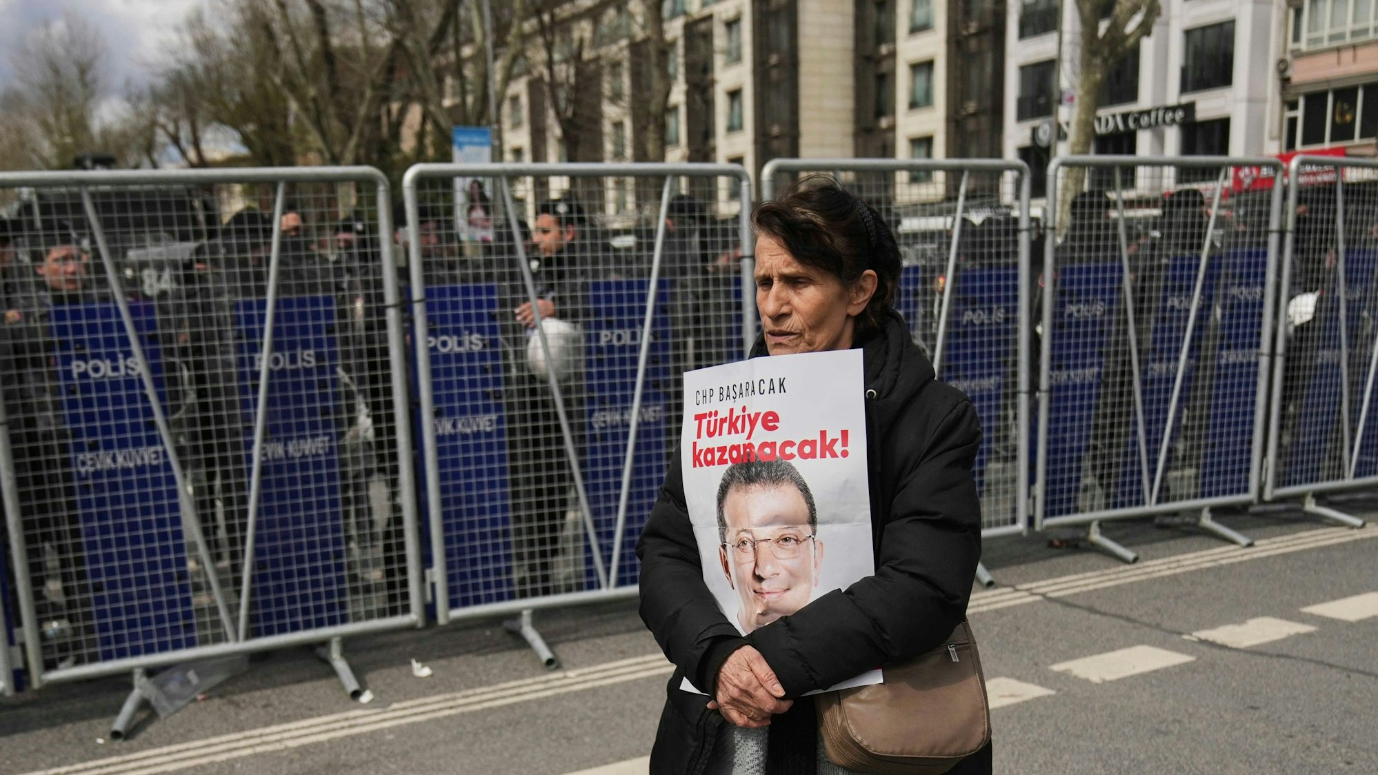 Eine Frau protestiert mit einem Plakat, das den Istanbuler Bürgermeister Ekrem Imamoglu zeigt vor einem Polizeiaufgebot in Istanbul
