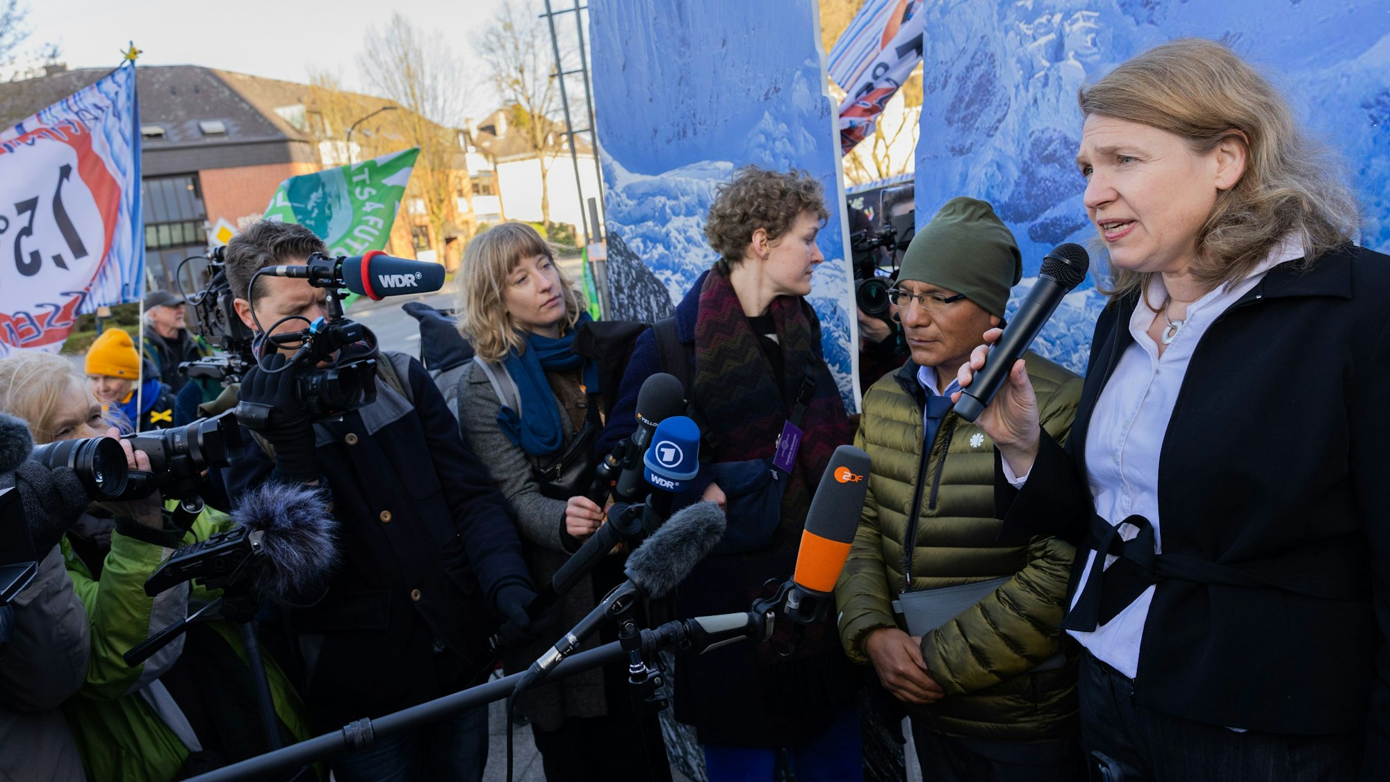 Der peruanische Bergbauer und Bergführer Saul Luciano Lliuya (2.v.r.) und seine Anwältin Roda Verheyen (r) kommen zur mündlichen Verhandlung seiner Klimaklage gegen das Energieunternehmen RWE in das Oberlandesgericht und sprechen zu Journalisten