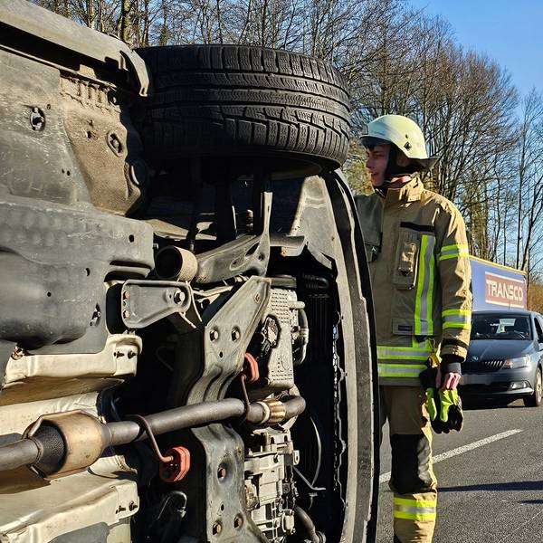 Ein Feuerwehrmann sichert ein umgestürztes Auto nach einem Unfall auf der A1.
