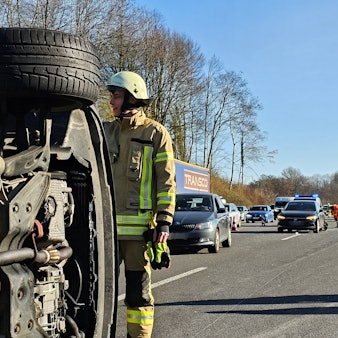 Ein Feuerwehrmann sichert ein umgestürztes Auto nach einem Unfall auf der A1.