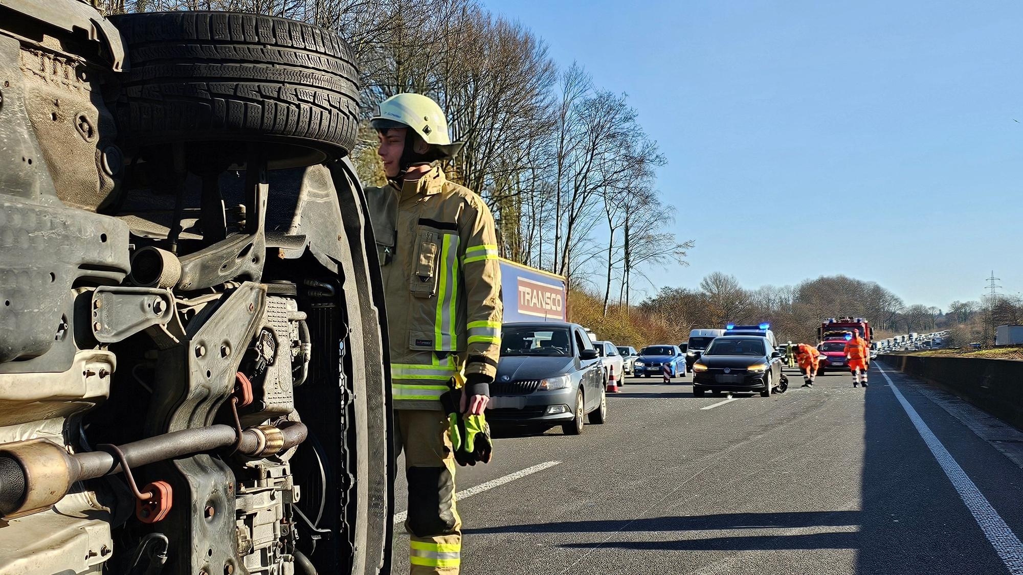 Ein Feuerwehrmann sichert ein umgestürztes Auto nach einem Unfall auf der A1.