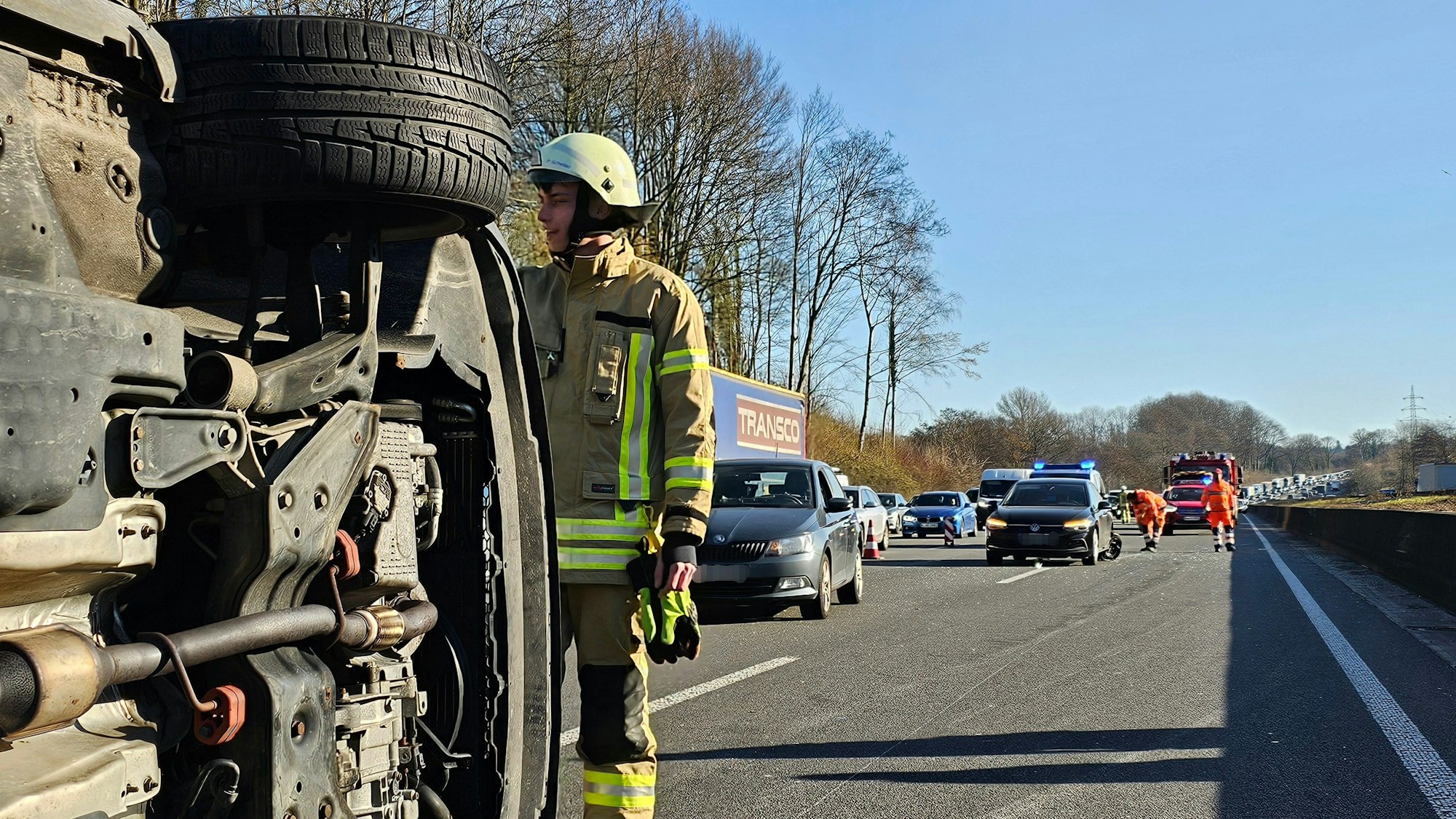 Ein Feuerwehrmann sichert ein umgestürztes Auto nach einem Unfall auf der A1.