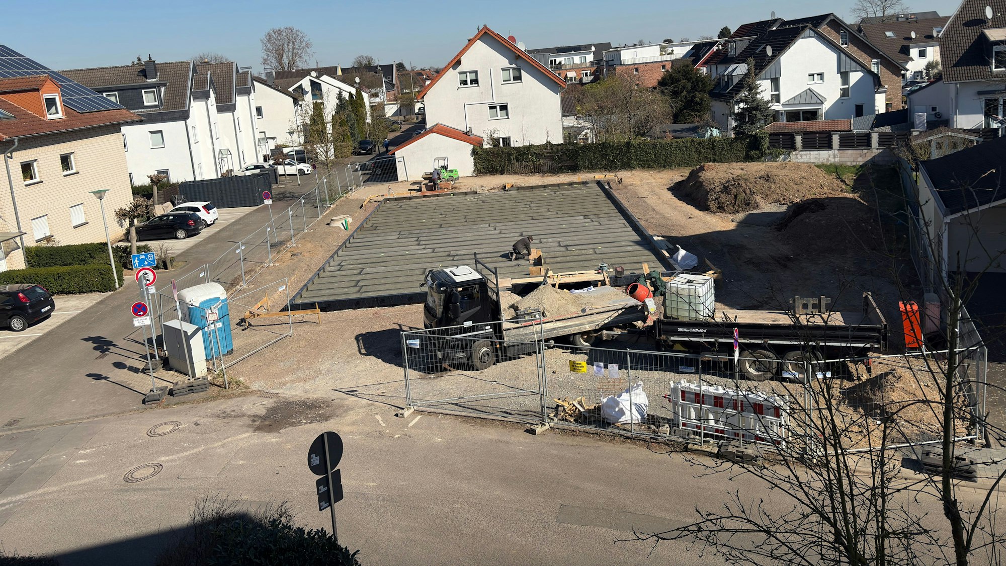 Eine Baustelle, im Hintergrund rechts liegt Bodenaushub.
