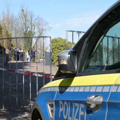Ein Polizeiwagen steht vor dem Tor des Volbergerer Friedhofs, Flatterband versperrt den Zugang.