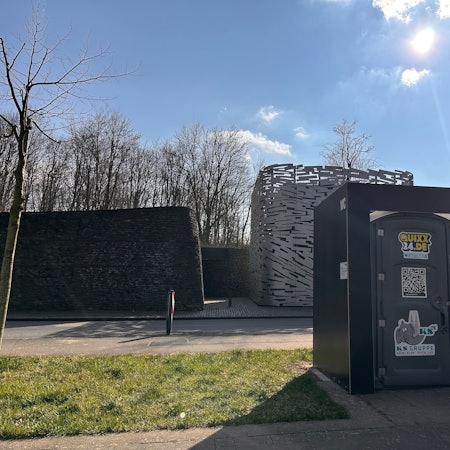 Vor einem Hochwasserpumpwerk in Rodenkirchen steht ein mobiles Toilettenhäuschen.
