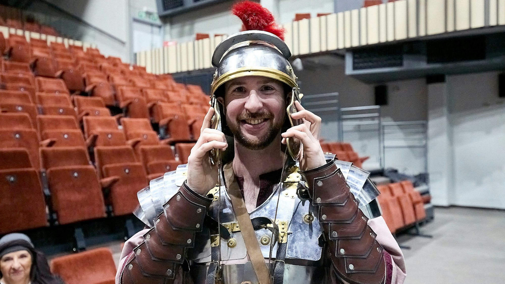 Ein Darsteller hat die Montur eines römischen Legionärs angelegt, der Helm mit dem roten Federbusch ist ihm aber zu groß.