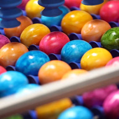 Frisch gefärbte Ostereier werden in der Ostereierfärberei auf einem Rollband zum Verpacken befördert.