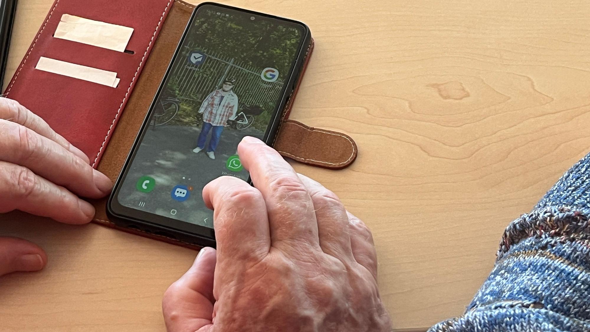 Ein Senior bedient sein Smartphone.