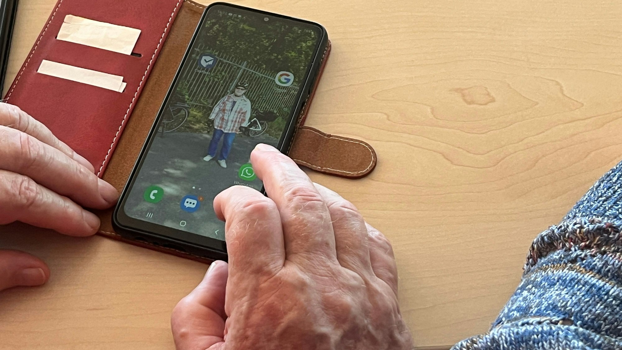 Ein Senior bedient sein Smartphone.