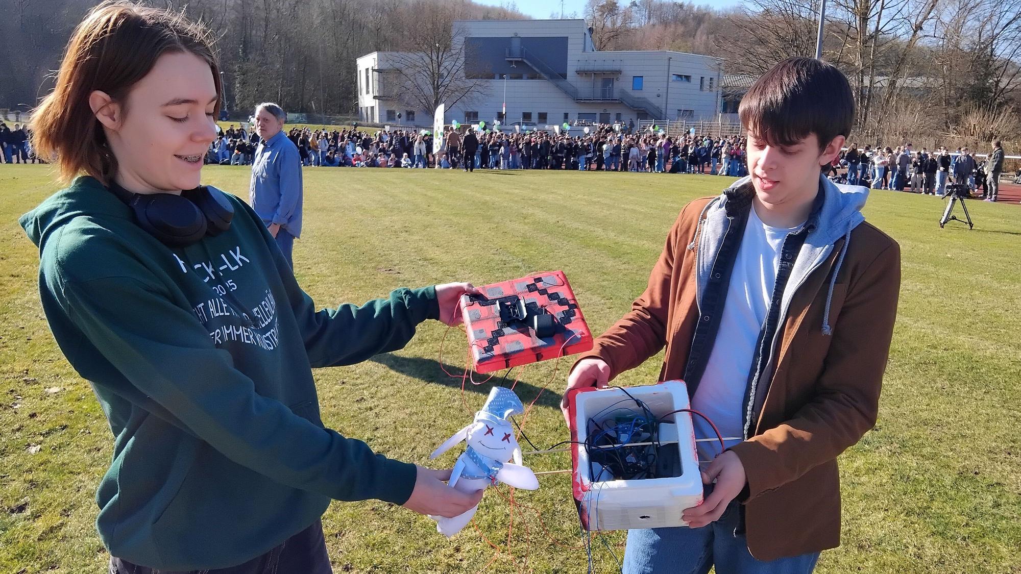 Eine Schülerin und ein Schüler zeigen die Technik des Wetterballons