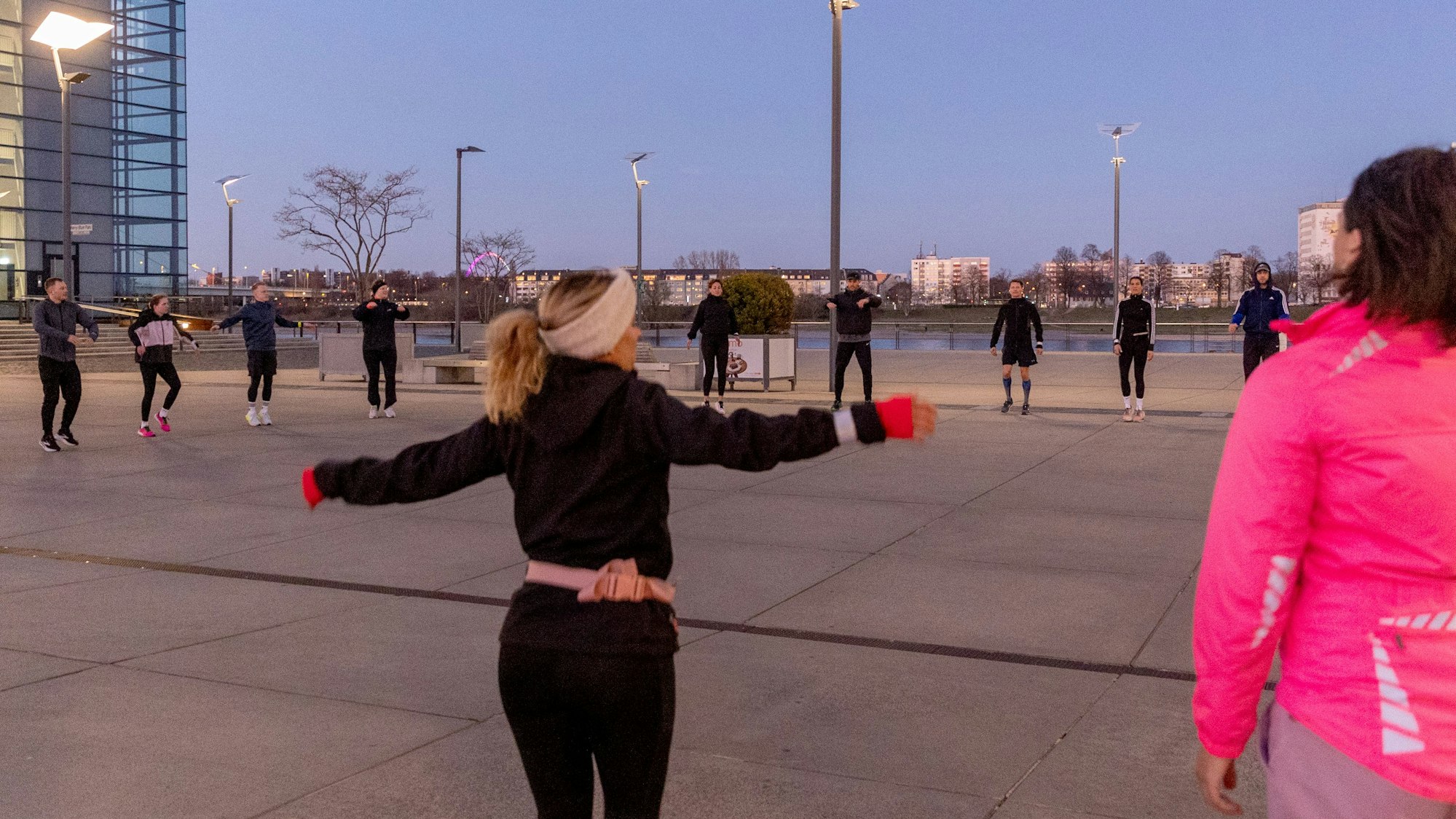 Läufer wärmen sich in Köln in einem Kreis auf
