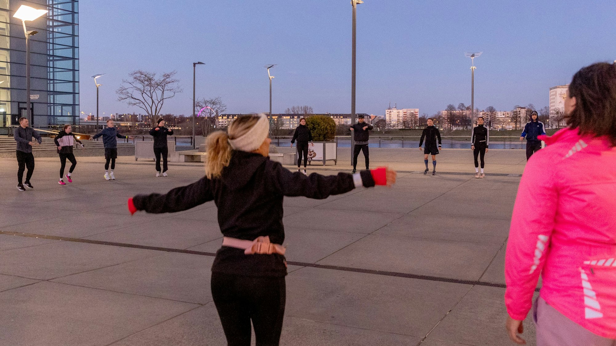 Läufer wärmen sich in Köln in einem Kreis auf