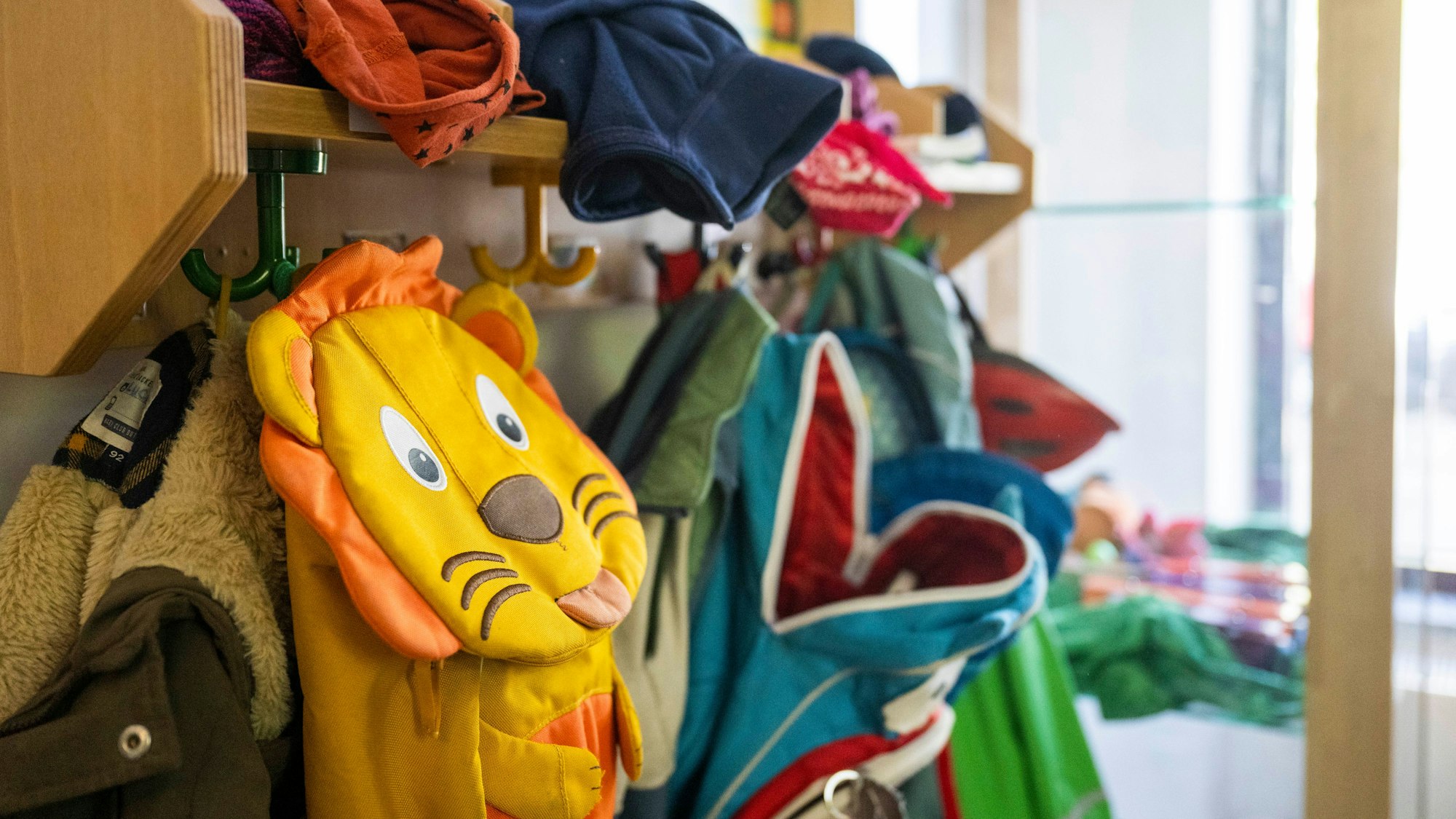 Kinderrucksäcke hängen in einer Garderobe einer Kita. Foto: Christophe Gateau/dpa