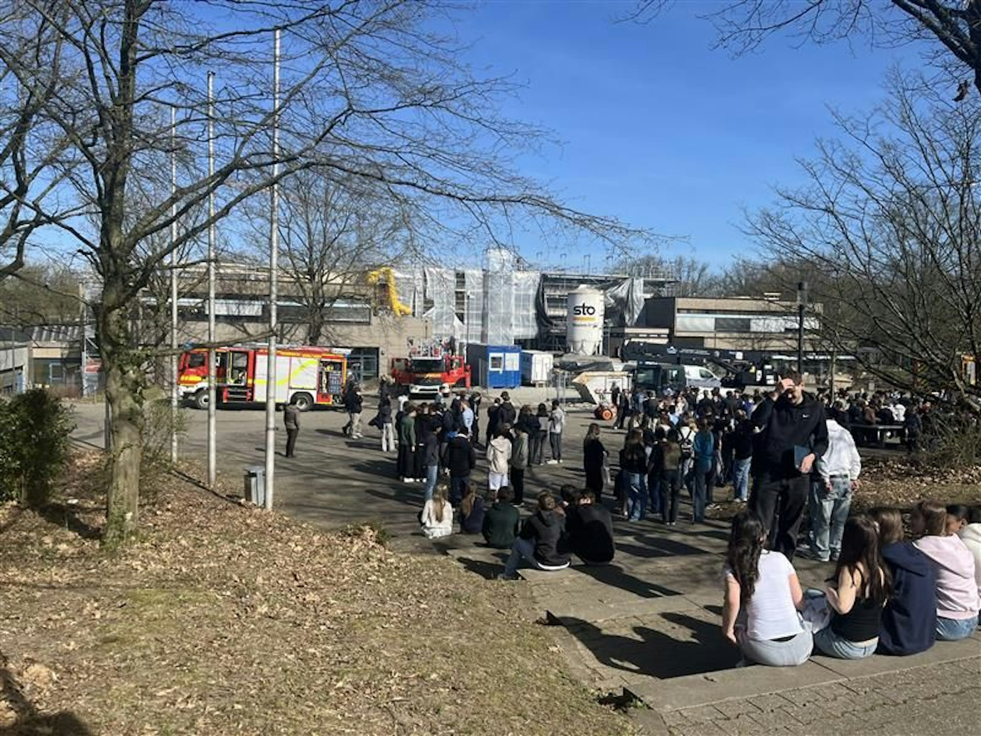 Die Schulgemeinschaft wartet auf dem Außengelände