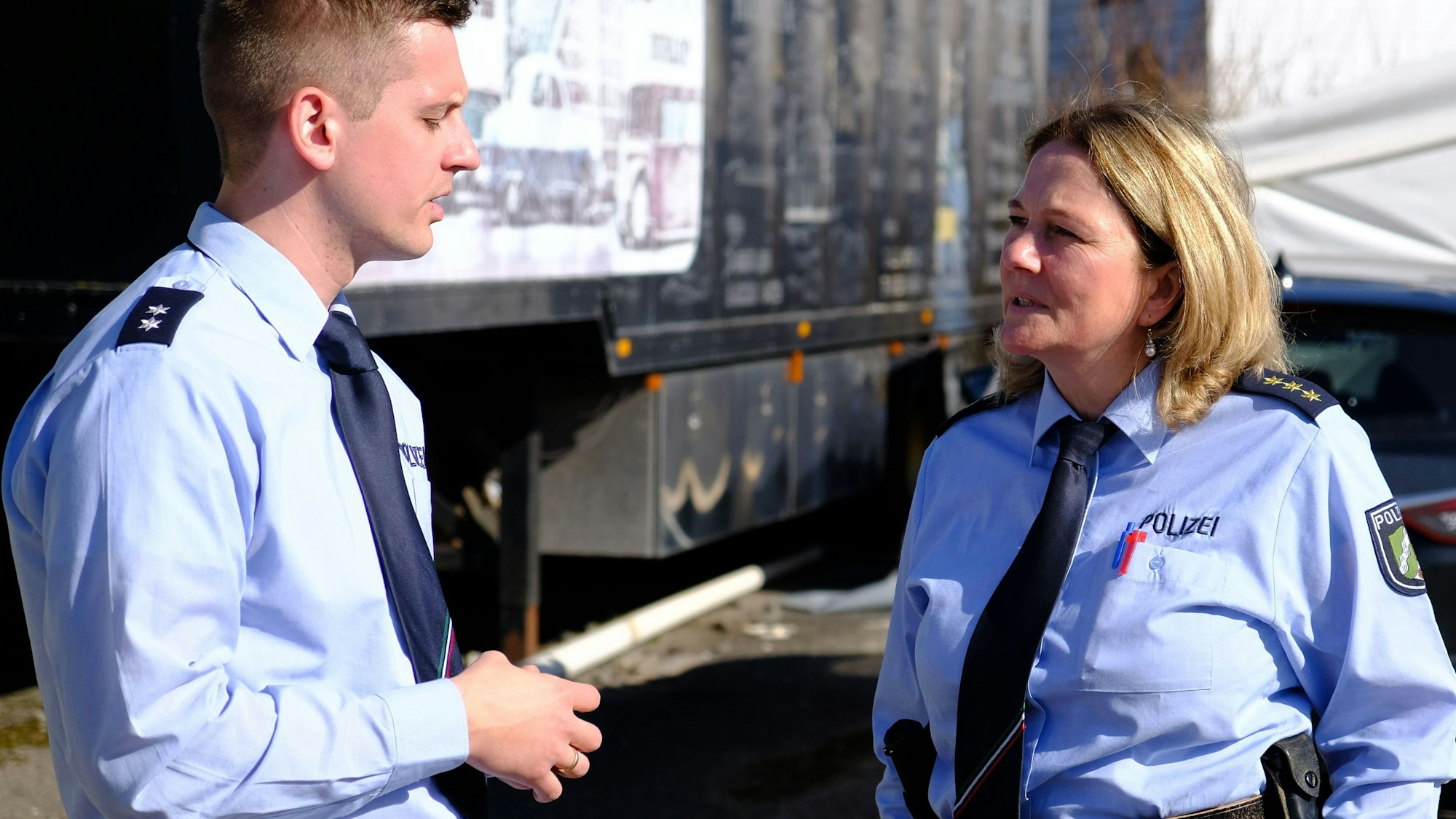Gabriele Mälchers, Chefin der Kreispolizei, im Gespräch mit einem Kollegen. Beide tragen hellblaue Uniformhemden.
