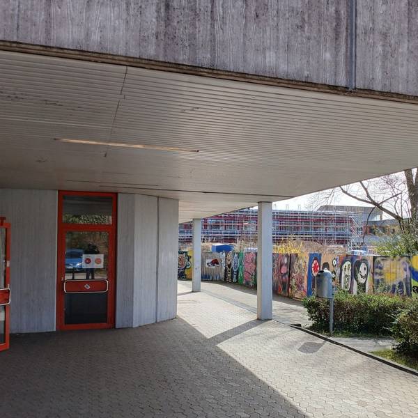 Ein Schulgebäude, im Hintergrund eine Baustelle.