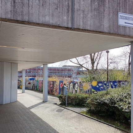 Ein Schulgebäude, im Hintergrund eine Baustelle.