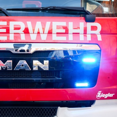Blaulichter leuchten an einer Einsatzstelle an einem Löschfahrzeug der Feuerwehr.