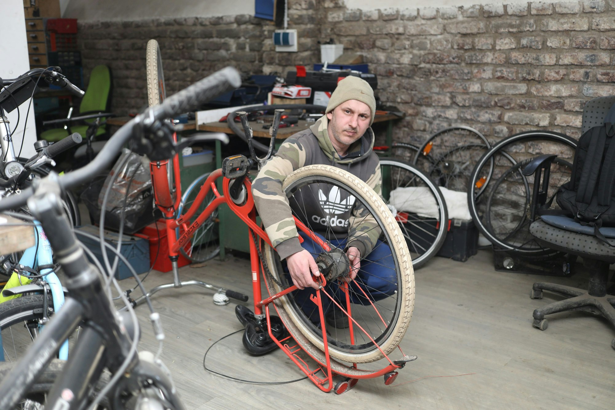 20.03.2025, Köln: Artuhr Krassmann (43) ist einer der Handwerker auf dem Schrottplatz. Die Schrottrad-Verwerter erwecken auf dem Verwertungshof an der Niehler Straße Schrotträder, die von der AWB eingesammelt wurden zu neuem Leben. Foto: Arton Krasniqi