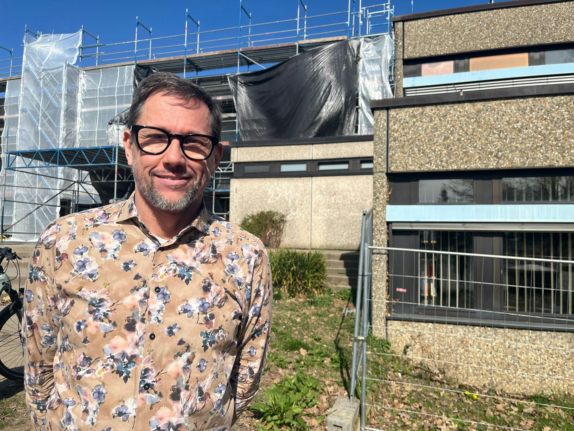 Schulleiter Kai Vrancken vor der eingerüsteten Schule.