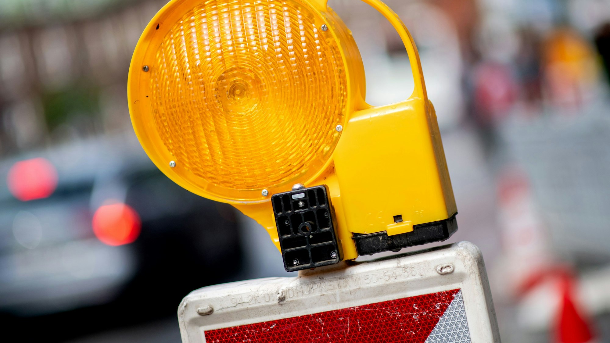 Eine Leitbake mit einer Warnleuchte steht an einer Baustelle.