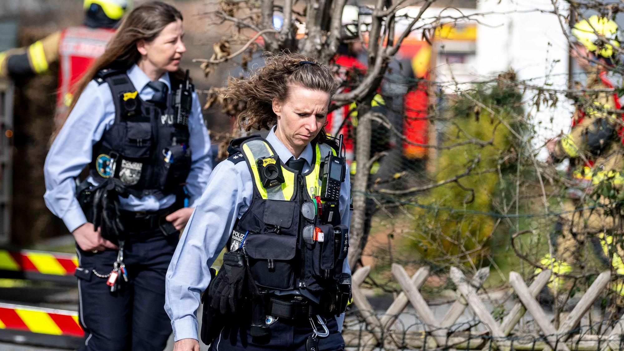 Das Bild zeigt zwei Polizeibeamtinnen, die die Einsatzstelle verlassen.